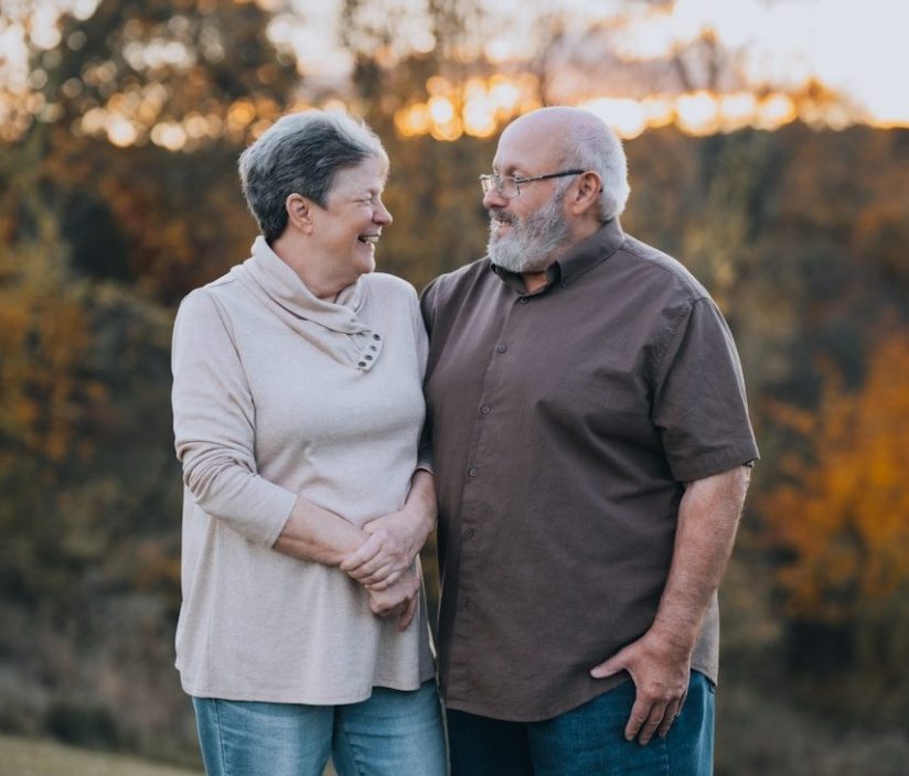 A man and woman standing next to each other in a field