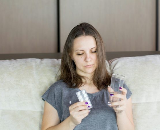 a woman sitting on a couch looking at her cell phone